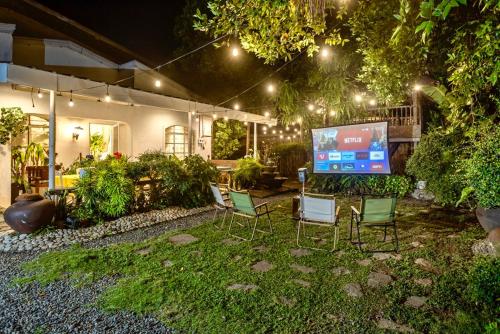 a yard with chairs and a screen in front of a house at Christmas Ready Villa with Outdoor Cinema and Bonfire 7 mins to Calle Crisologo in Vigan