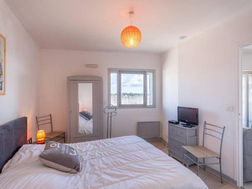 a bedroom with a bed and a desk and a television at Charmant T2 avec vue port, idéal pour 4 pers. à La Trinité-sur-Mer - FR-1-477-78 in La Trinité-sur-Mer