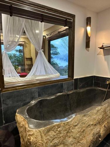 a bathroom with a large tub in front of a mirror at Amigo Pu Luong in Làng Bang