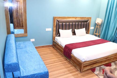 a bedroom with a bed and a mirror and blue walls at Blest Inn Kasol in Jāmb