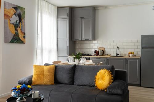 a living room with a couch and a kitchen at Urban Modern Apartment - AFI Arad in Arad