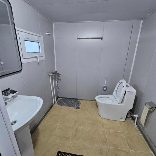 a bathroom with a white toilet and a sink at Nomad equestrian Luxury Ger camp in New Ulaanbaatar International Airport