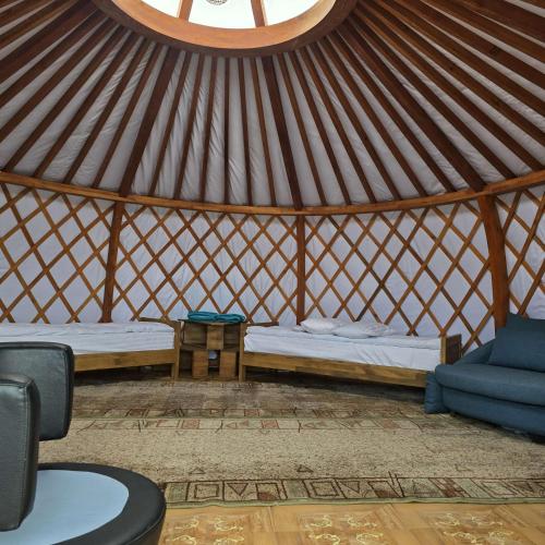 a yurt with two beds and a couch in it at Nomad equestrian Luxury Ger camp in New Ulaanbaatar International Airport