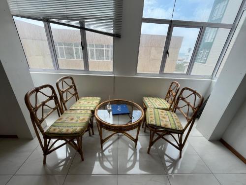 a table and chairs in a room with windows at By the Sea in Swakopmund
