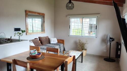 una sala de estar con una mesa y un sofá en Apart Fincas de San Pablo II, en Deán Funes