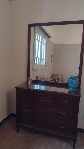 een ladekast in een kamer met een grote spiegel bij Córdoba y Colon in Mar del Plata
