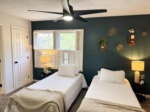 a bedroom with two beds and a ceiling fan at Azalea: 2 primary bedrooms w/ bathrooms in Augusta