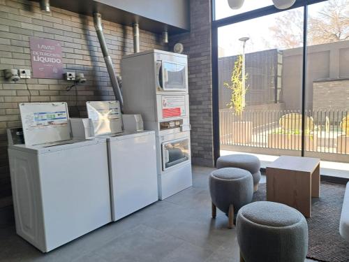 a kitchen with refrigerators and stools in a room at Departamento Nuevo 1D1B con estacionamiento sobre stripcenter y supermercado in Los Ángeles