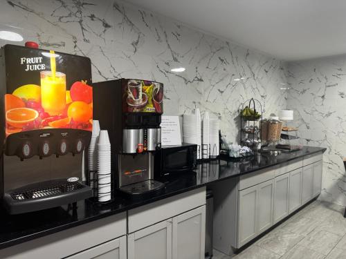 a kitchen with a counter with a fruit juice machine at Roseville Inn in Roseville