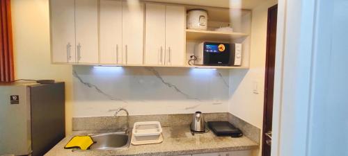 a kitchen counter with a sink and a microwave at Condo in Silang near Nuvali - Dy's Haven Suites in Silang