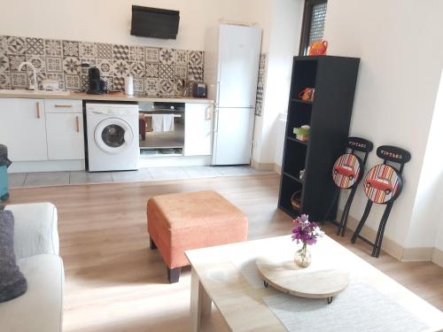 Foix centre - T2 vue sur le Château في فوا: غرفة معيشة مع أريكة وطاولة ومطبخ