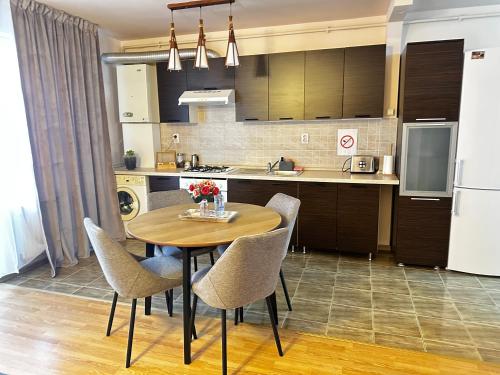 una cucina con tavolo e sedie in una cucina di Apartament Terra II a Floreşti