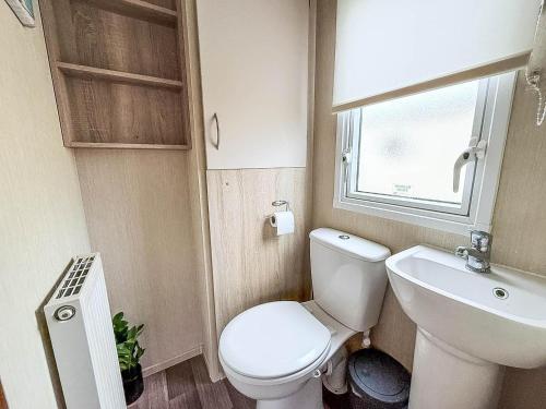 Cosy 6 Berth Caravan With Side Decking At Kessingland Beach, Suffolk Ref 90031Sv في Benacre: حمام صغير مع مرحاض ومغسلة