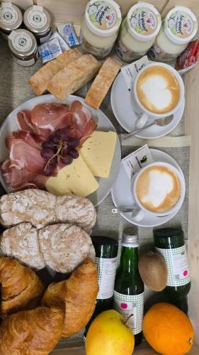 uma mesa com pratos de queijo, pão e bebidas em ecHo Apartments & SPA em Bressanone