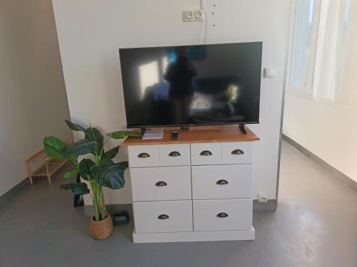 a television on top of a dresser in a room at T2 a St Nazaire, 500 mètres de la plage in Saint-Nazaire