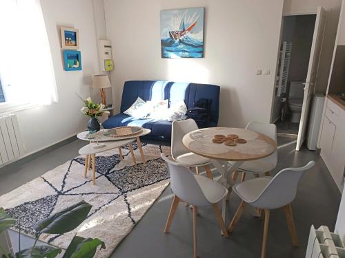 a living room with two tables and a couch at T2 a St Nazaire, 500 mètres de la plage in Saint-Nazaire