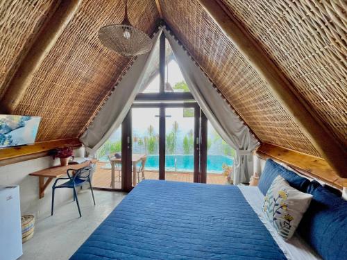 a bedroom with a large bed with a large window at Pousada Villa di Luna in São Miguel do Gostoso