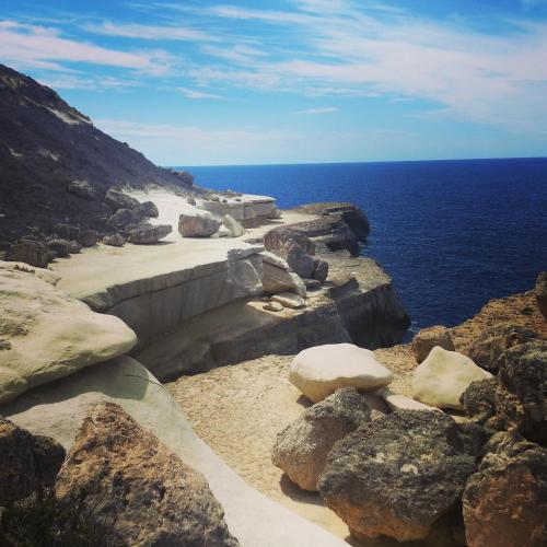 a group of rocks on a cliff near the ocean at Sunshine Court in St Paul's Bay