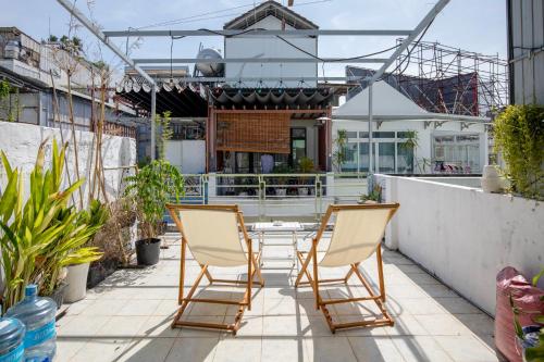 ホーチミン・シティにあるKibou Homestayのパティオに椅子2脚とテーブル1台