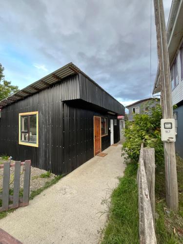 a black clad house with a black facade at Habitación independiente con baño privado in Cochrane