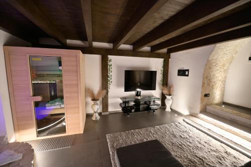 un soggiorno con TV a schermo piatto e divano di Eterea Wellness Suites a Montescaglioso