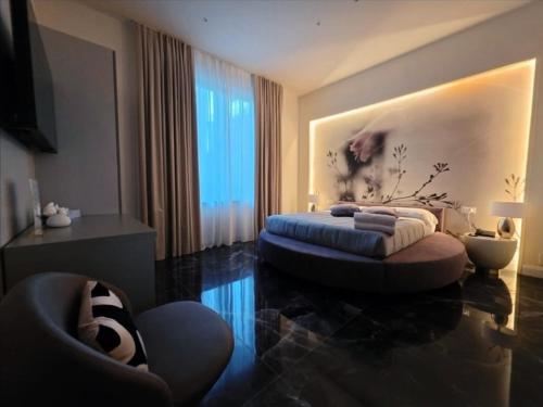 a living room with a bed and a chair at Mirarti Boutique Hotel - Witamy in Rapallo