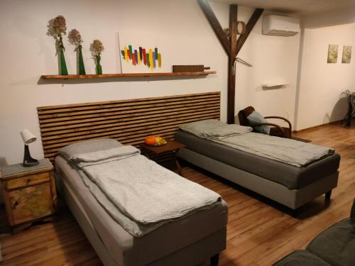 a bedroom with two beds and a wooden floor at Wolna Chwila in Maków