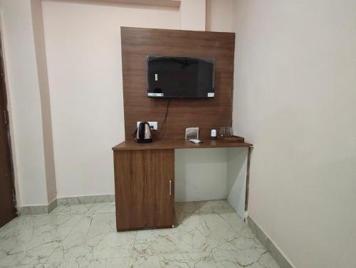 Zimmer mit einem TV an der Wand in der Unterkunft Hotel Ardent in Ranchi