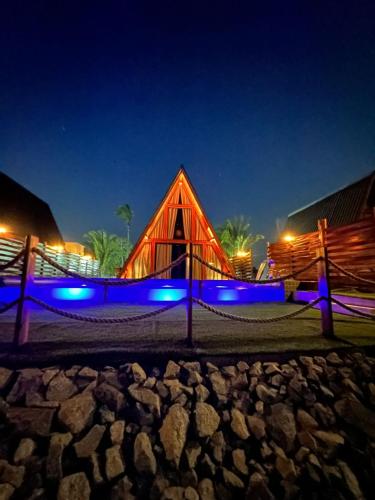 un edificio in legno con luci blu di notte di LIMMAT Chalés a Hora