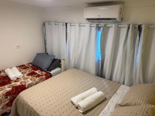 a small bedroom with two beds and a tv at Apartamento do Padin 2-2ª Praia in Morro de São Paulo