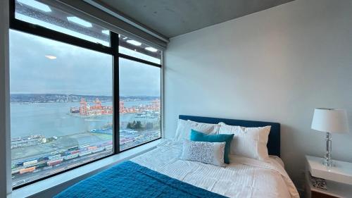 ein Schlafzimmer mit einem Bett und einem großen Fenster in der Unterkunft Ocean and Mountain View Home - Downtown Vancouver in Vancouver