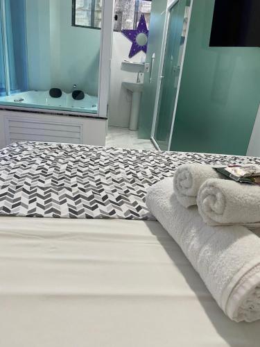 a bathroom with a bed with a shower and towels at Hotel Lumiar in Lumiar