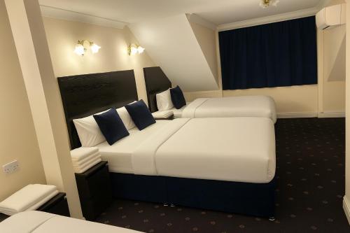 a hotel room with two beds and a window at shabi inn in Ilford