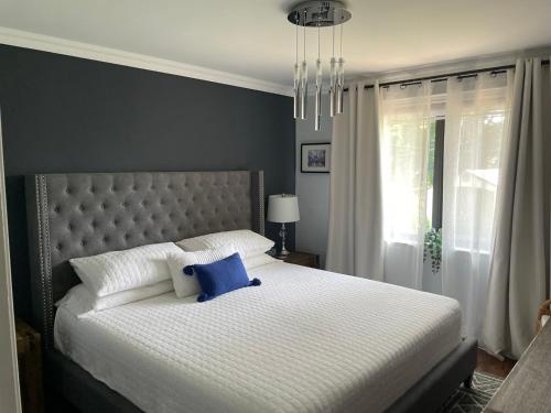 a bedroom with a large bed with a blue pillow on it at Modern Retreat with Hot tub by YYZ, 20min to CN Tower in Toronto