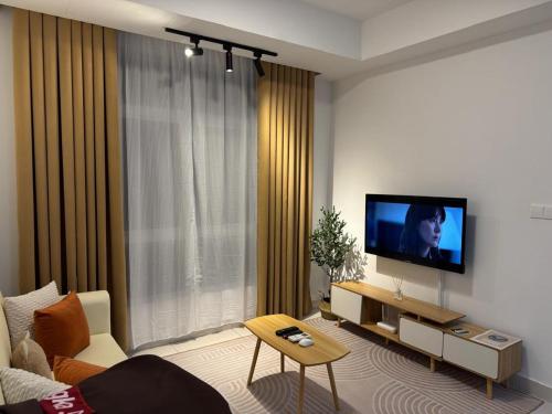 ein Wohnzimmer mit einem Flachbildfernseher an der Wand in der Unterkunft Mirai Residence Kajang 2 UKM Bangi GMI in Kajang