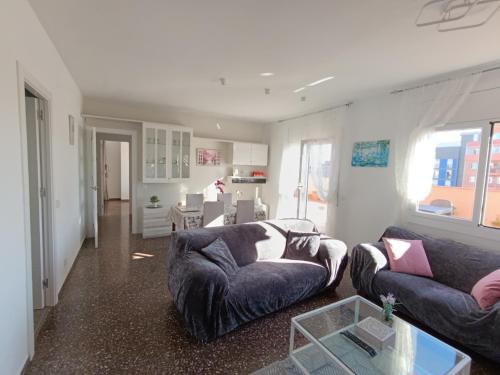 a living room with two couches and a table at Cozy and sunny penthouse Fira BCN in Hospitalet de Llobregat