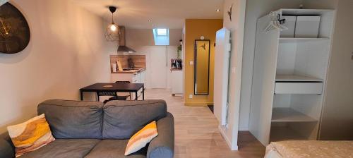 Votre Refuge Urbain Logement Complet pour Étudiants et Pros في فوجير: غرفة معيشة مع أريكة وطاولة