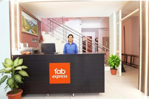 a man standing behind a reception desk in an office at Via Earth- Nr Vadapalani Murugan Temple, Vadapalani in Chennai