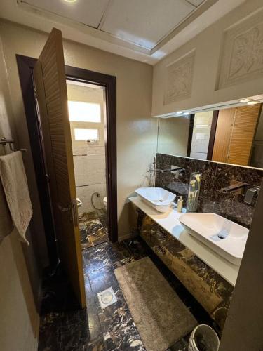 a bathroom with two sinks and a mirror at Studio attached to huge villa include access to villa also in Ajman