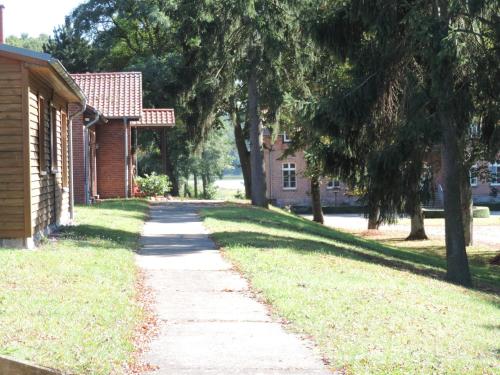 a sidewalk in front of a house with trees at Gut Settin am See - Ferienhäuser in Settin