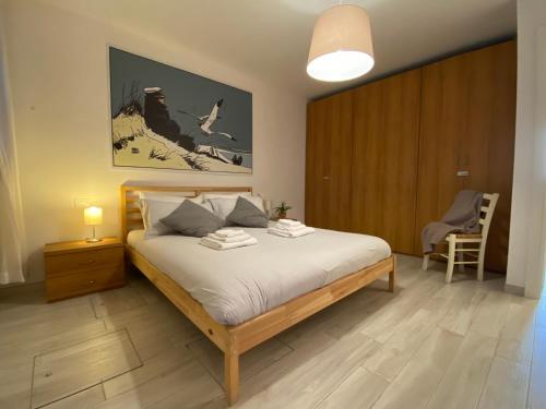 a bedroom with a large bed and a chair at Casa Marisa - facing campo in Murano - Venezia in Murano