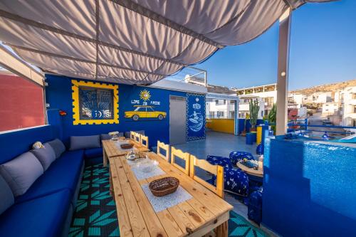 een eetkamer met een tafel en een zwembad bij Nomazigh Surf House in Tamraght Ouzdar