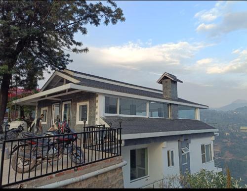 Una casa con un balcón con bicicletas. en Twin Oaks Kasauli Hills, en Kasauli