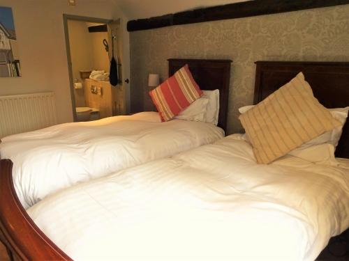 two beds sitting next to each other in a bedroom at The Cross Keys in Saffron Walden
