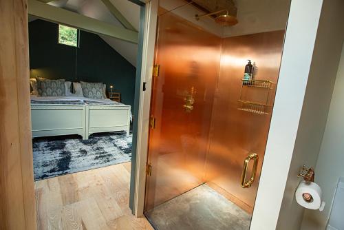 ein Badezimmer mit Dusche und ein Bett in einem Zimmer in der Unterkunft Coombe Farm Goodleigh - The Stables in Goodleigh