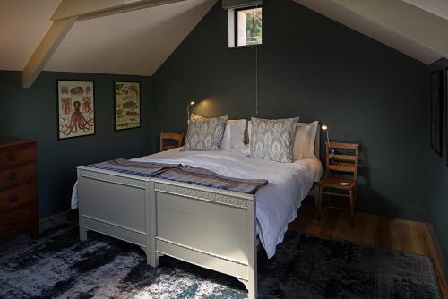 ein Schlafzimmer mit einem Bett mit einem weißen Bettrahmen in der Unterkunft Coombe Farm Goodleigh - The Stables in Goodleigh