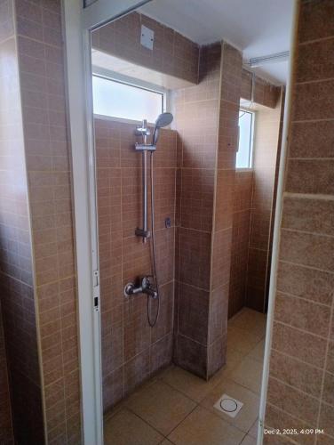 a shower in a bathroom with brown tile at Shoka escape farm- Double room