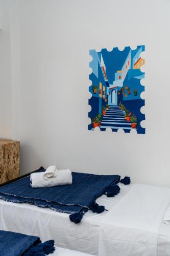 a bedroom with a bed with a painting on the wall at Nomazigh Surf House in Tamraght Ouzdar