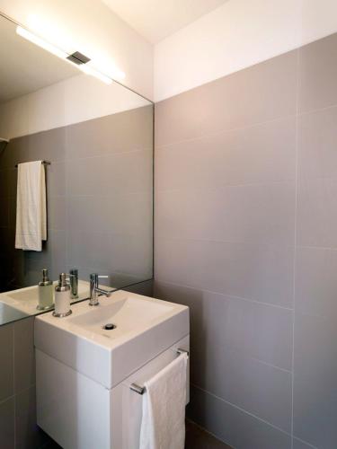 a white bathroom with a sink and a mirror at Uporto House Villa in Porto