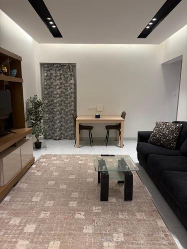 a living room with a couch and a table at Abu Rakan Apartment in Muscat